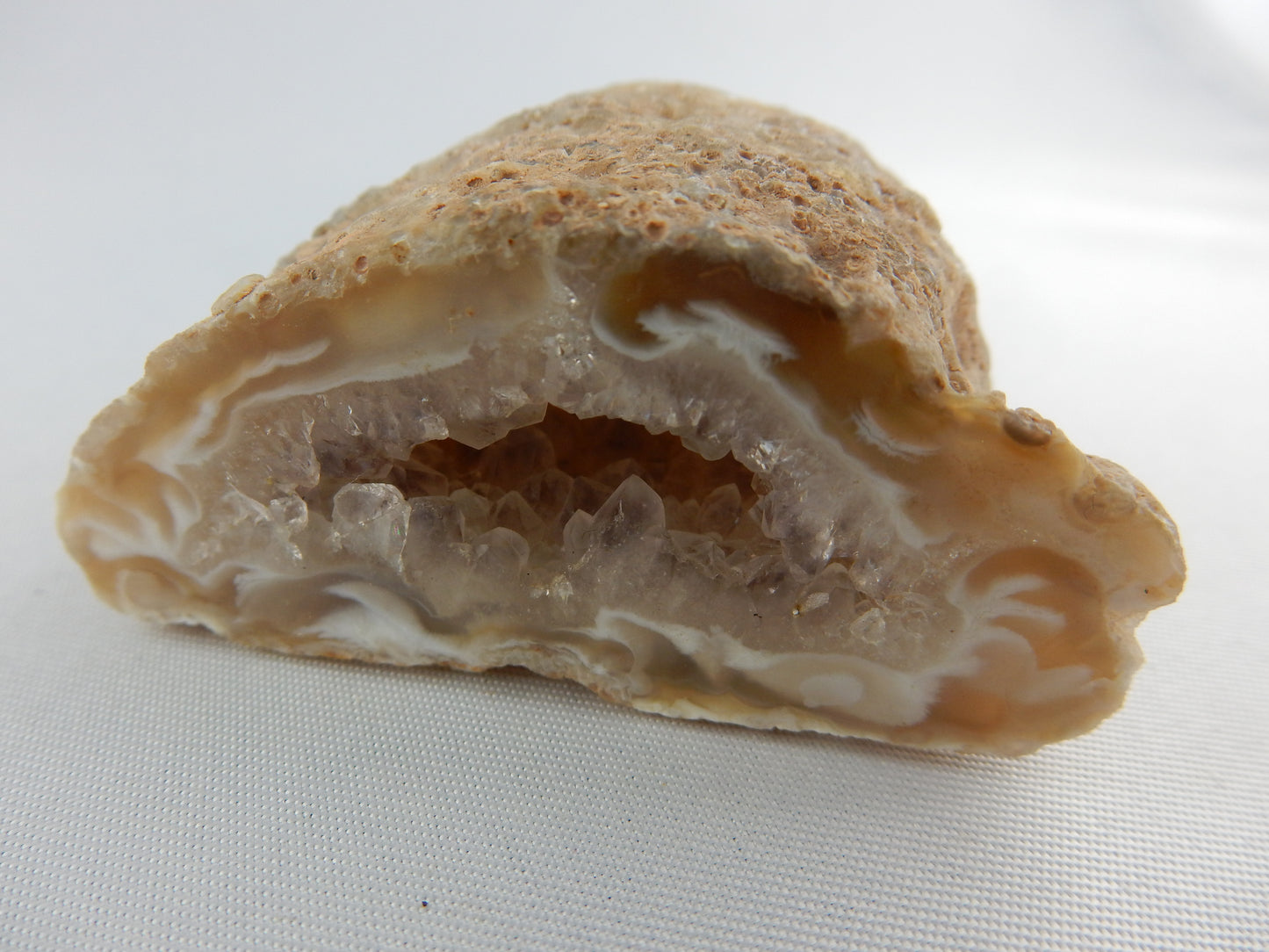 Unique cute little agate geode with "wispy" swirls at entrance and sparkly terminated quartz inside