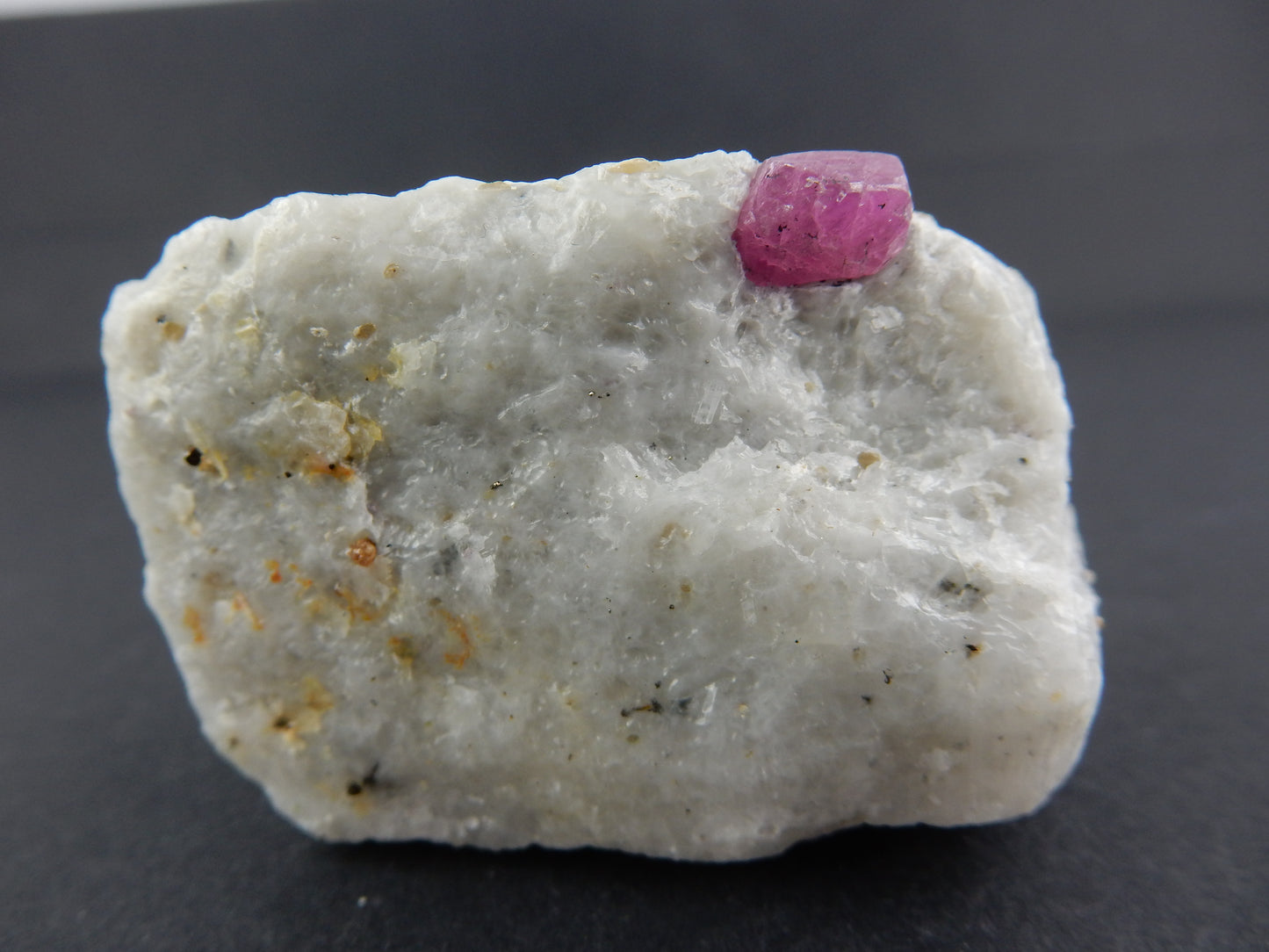 nice gemmy-blocky terminated RUBY RED crystal (strong UV) on bed or white marble and shiny Phlogopite mica