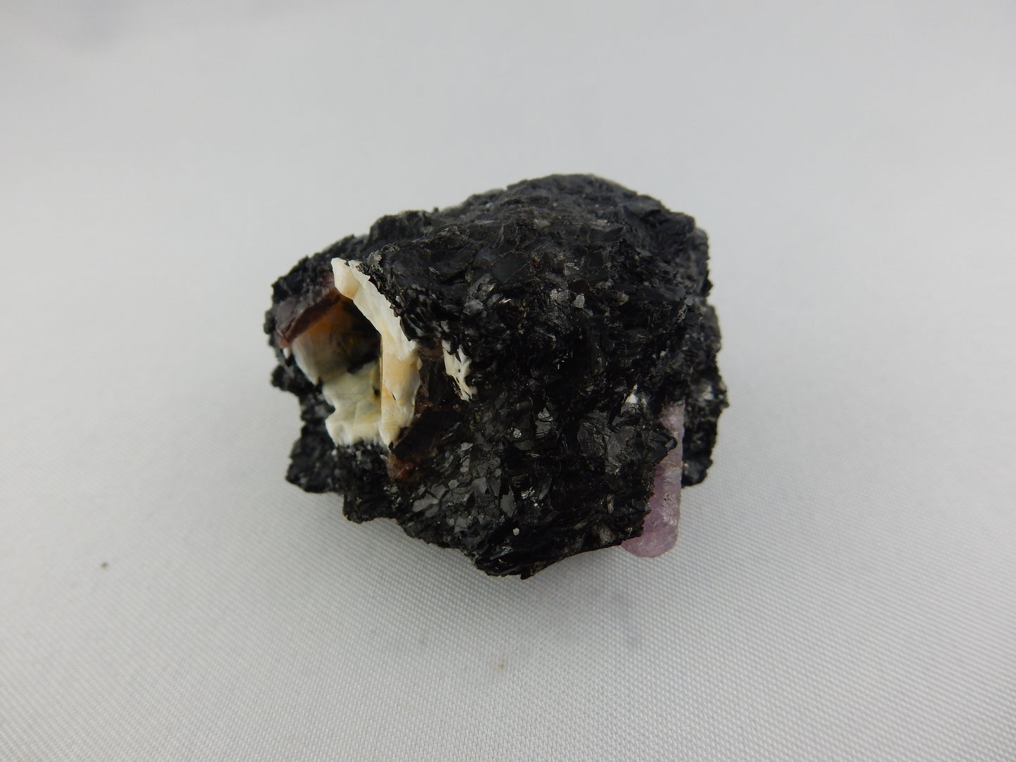 Very rare purple sapphire (corundum) terminated point (and 2 other small) in matrix of black biotite and sphalerite