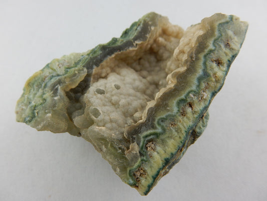 Unusual green-coloured (malachite in quartz?) banded geode with botryoidal chalcedony center