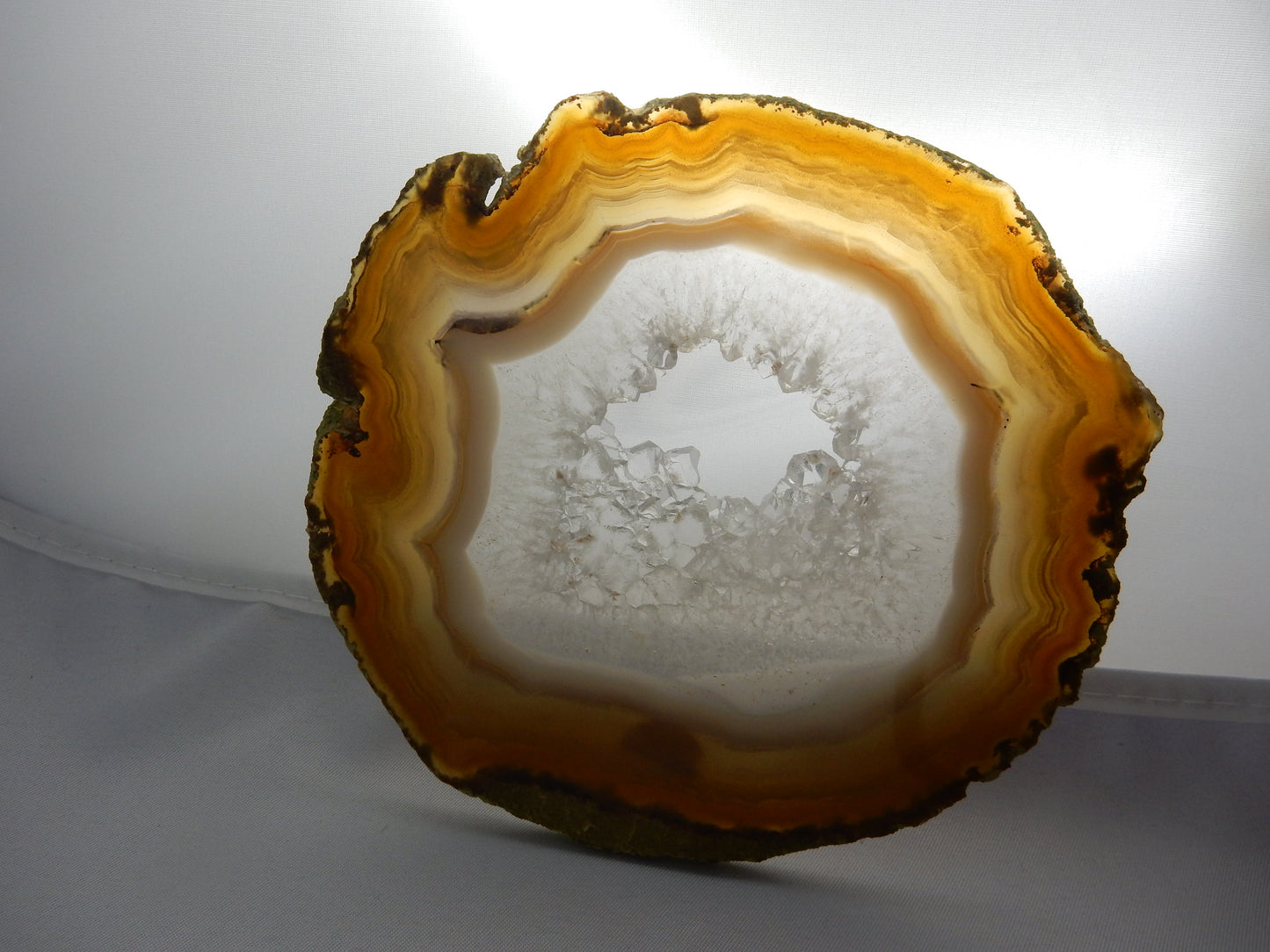 Big beautiful nicely polished slice of banded agate with gemmy quartz crystal center