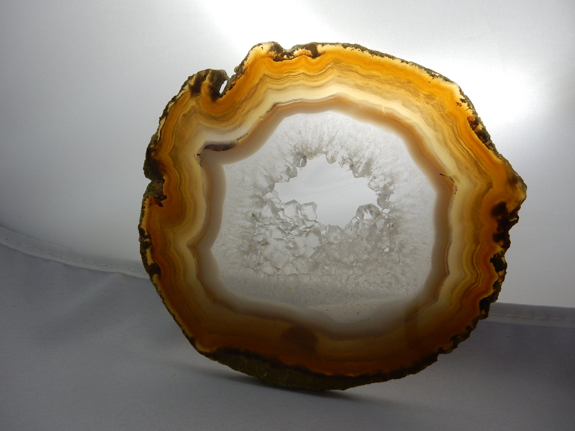 Big beautiful nicely polished slice of banded agate with gemmy quartz crystal center