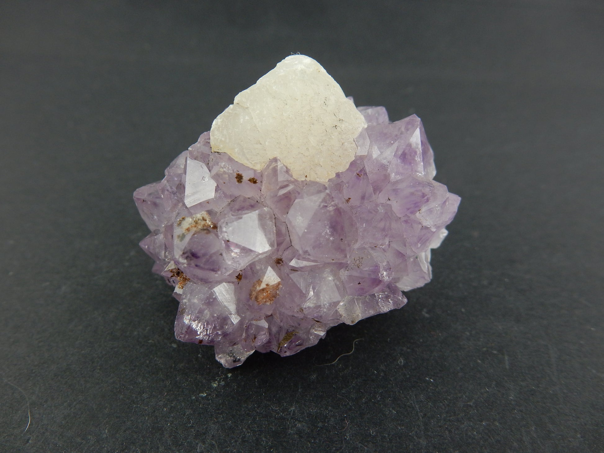 UV Orange Fluorescent Calcite modified cubic crystal nestled in a wreath of sparkly light purple amethyst!