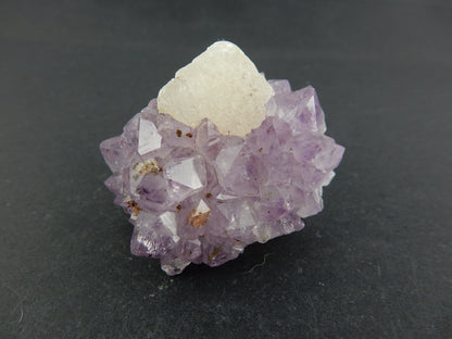 UV Orange Fluorescent Calcite modified cubic crystal nestled in a wreath of sparkly light purple amethyst!