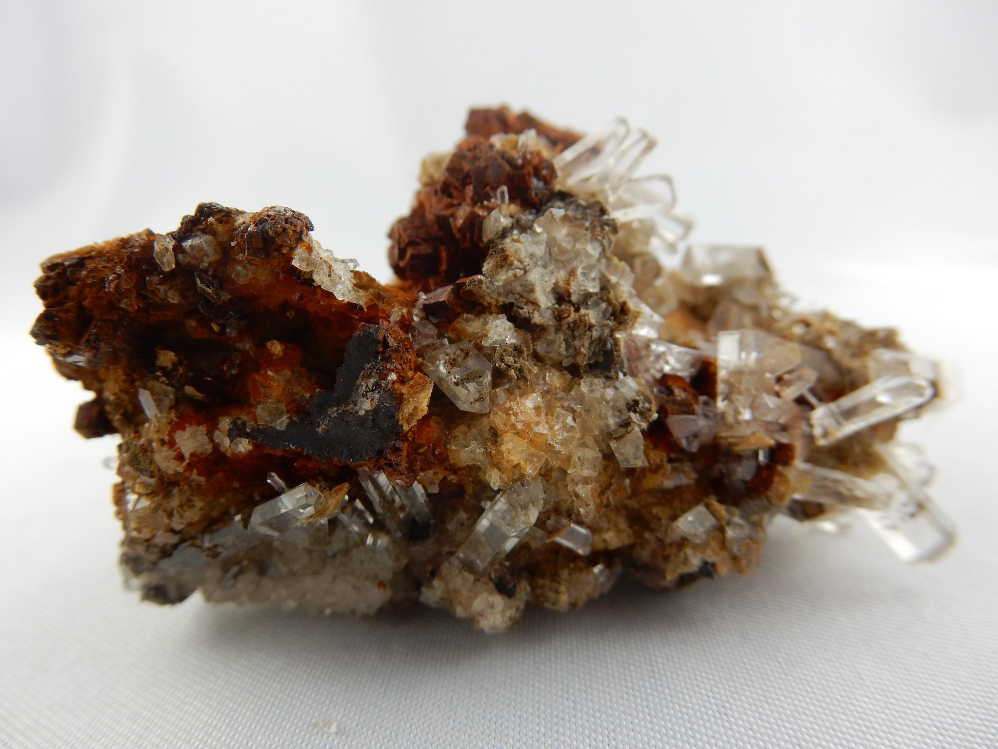 super-gemmy clear calcite terminated columns clusters on rusty brown matrix - great contrast/show
