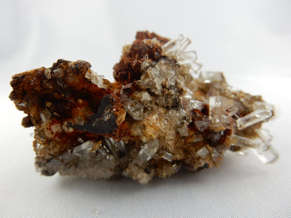 super-gemmy clear calcite terminated columns clusters on rusty brown matrix - great contrast/show