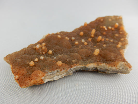 weird plate of orange clacite with many small "stalagmites" of yellow calcite - cave formation