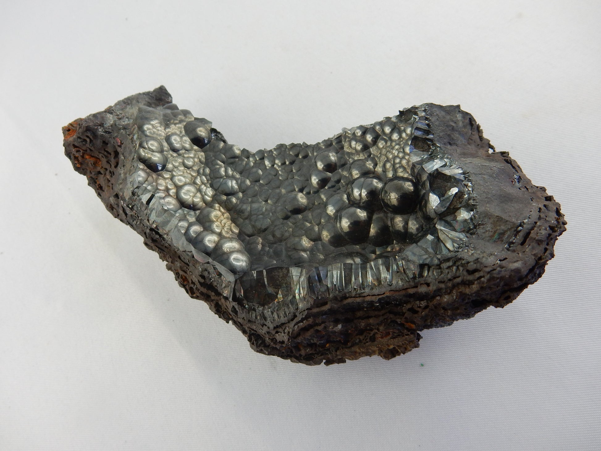 Amazing gemmy botryoidal mass sitting on curved bed of hematite