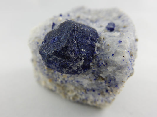 complete dodecahedron single Lazurite crystal perched on calcite and smaller lazurite, pryite and phlogopite