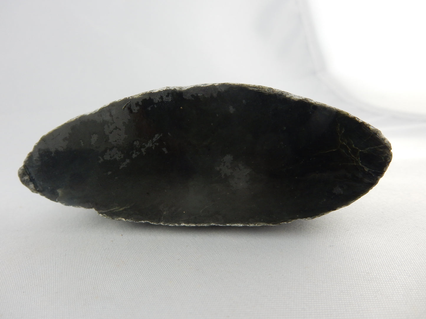 Half a small flattened boulder specimen (or polishing raw) of dark NZ "Kawakawa" - classic white "skin" - part natural stream worn/part cut/polished