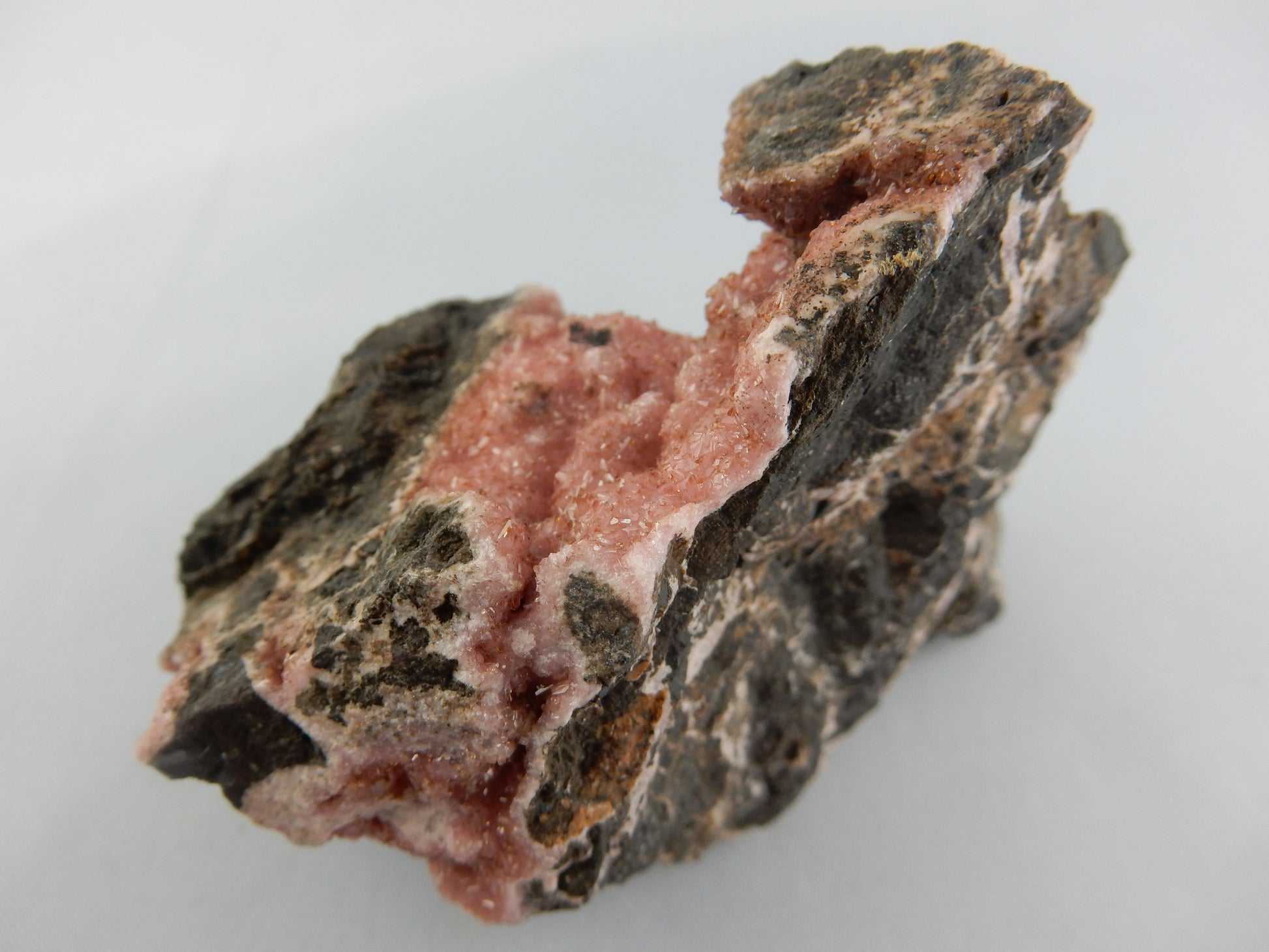 Rhodochrosite - big showy specimen of sparkly pink druse on matrix of black basalt