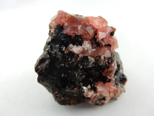 rhodochrosite cluster of sparkly-gemmy dark pink terminated SCALENOHEDRAL crystals well-set-off on bed of black sphalerite matrix