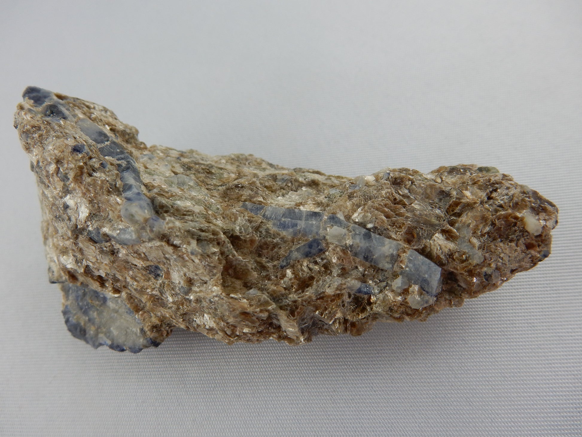 multiple deep blue/white Sapphire scaledahedron double terminated crystals "floating" in a bed of sparkly muscovite