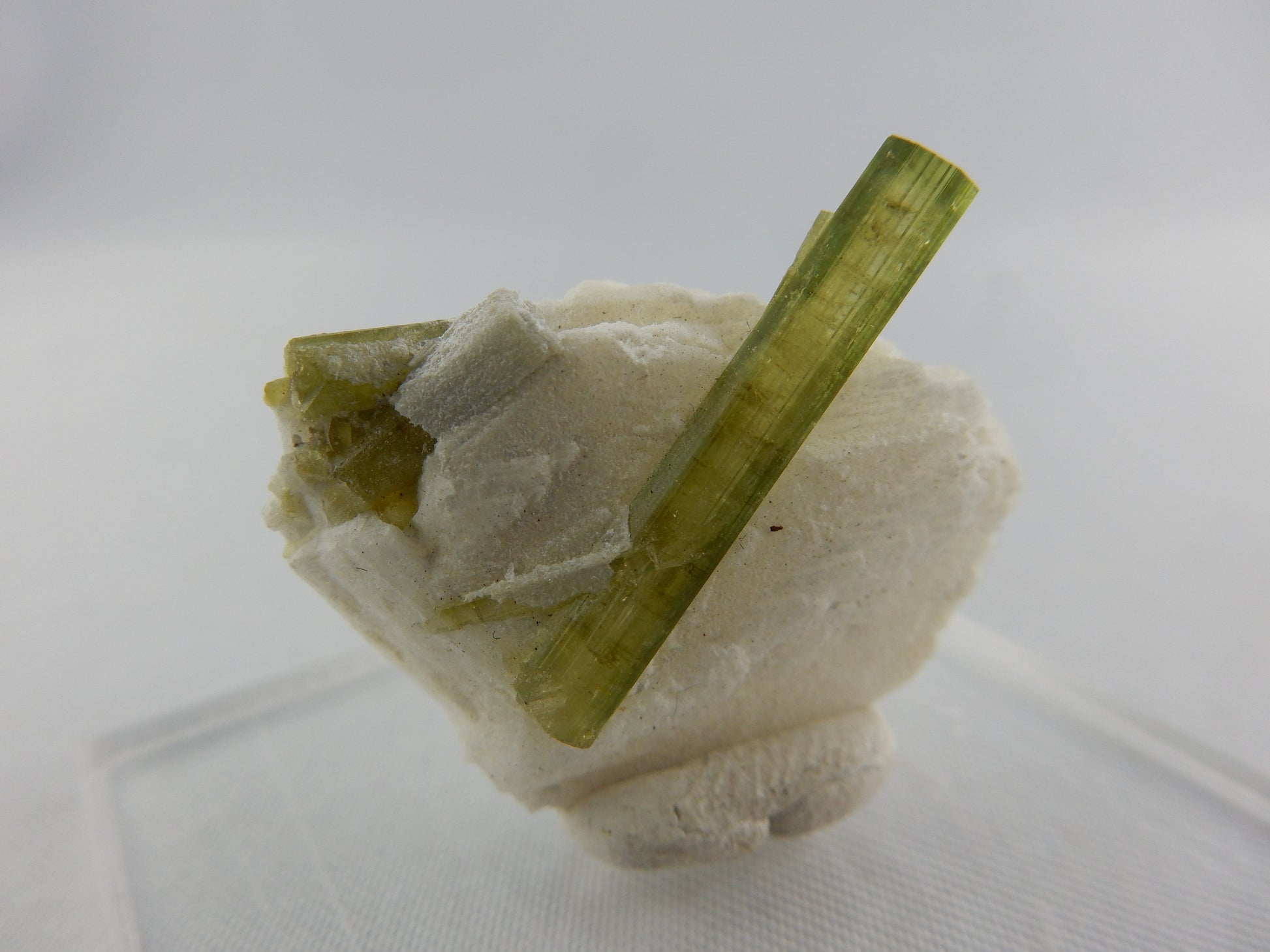 gemmy clear watermelon (viewed down C-axis of perfect flat sharp termination) lying on a bed of cleavlandite