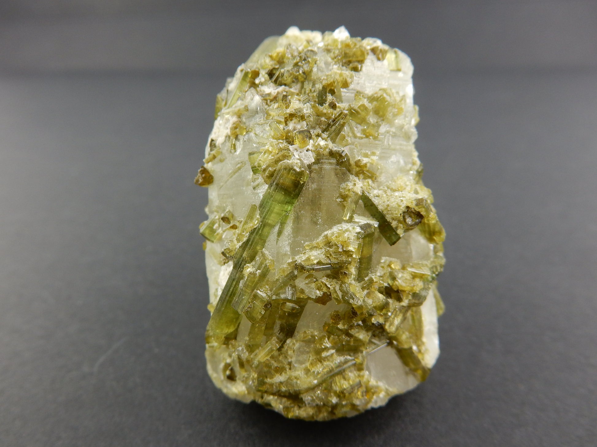 gemmy sparkly green terminated tourmaline "smothering" a single quartz crystal 