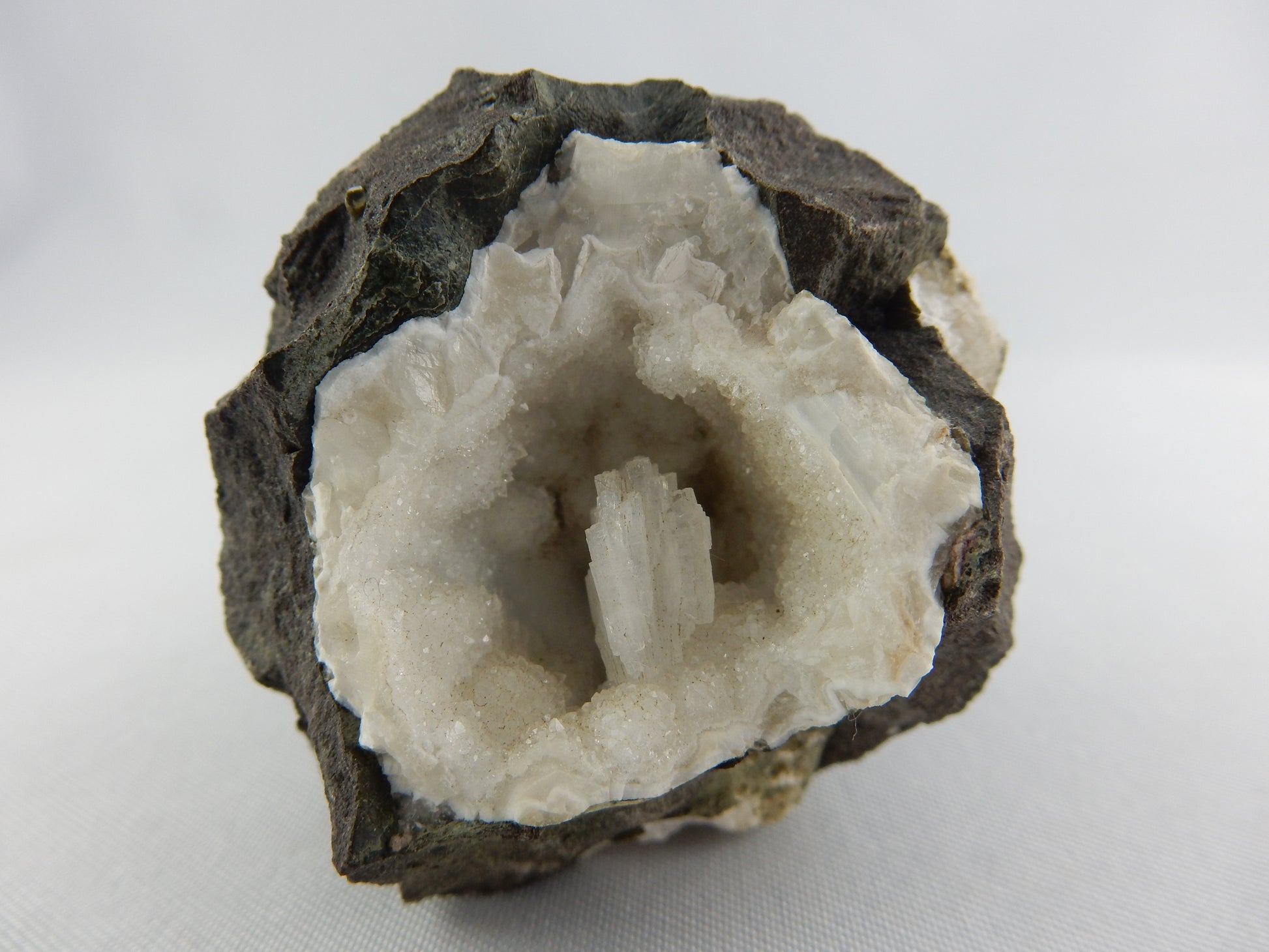 nice complete crystal in geode of other crystals in contrasting black basalt
