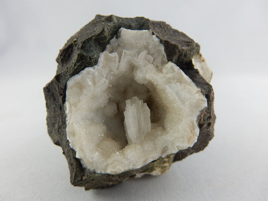 nice complete crystal in geode of other crystals in contrasting black basalt