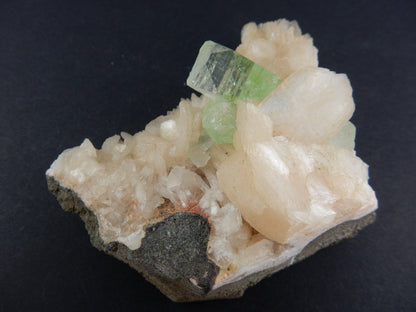 gemmy green point of Apophyllite on a bed of orange-pink Stilbite, on basalt