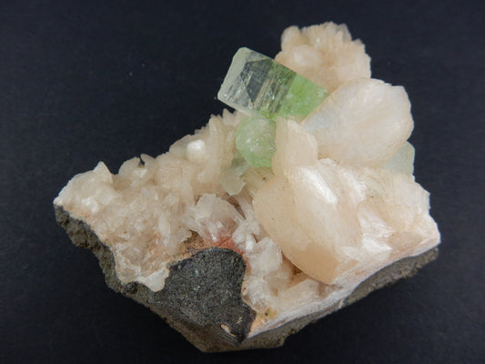 gemmy green point of Apophyllite on a bed of orange-pink Stilbite, on basalt