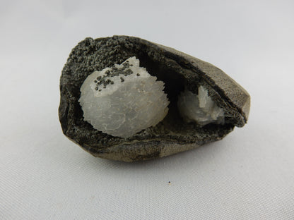 White gemmy stack of Heulandite nestled in a black calcite(?) and volcanic matrix vug