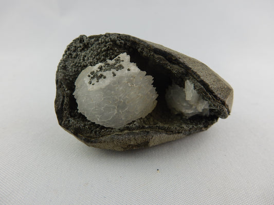 White gemmy stack of Heulandite nestled in a black calcite(?) and volcanic matrix vug