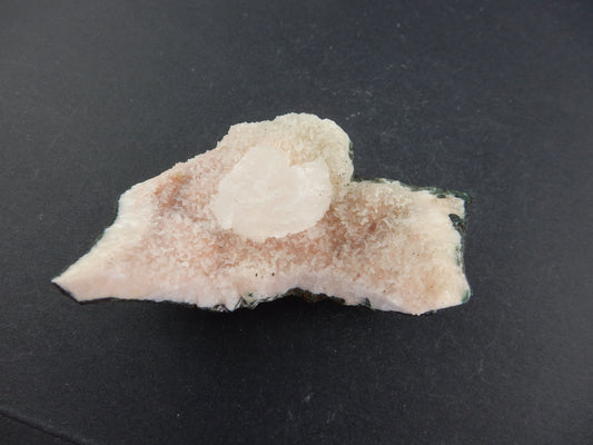 Classic "coffin-shaped" curved white cluster of Heulandite on a bed of stilbite?+calcite vug in volcanic matrix